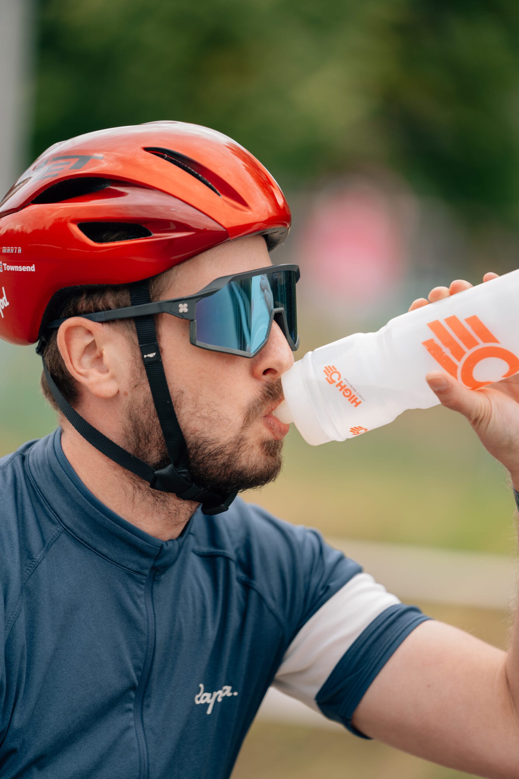 man with cycle helmet drinking out of a bottle