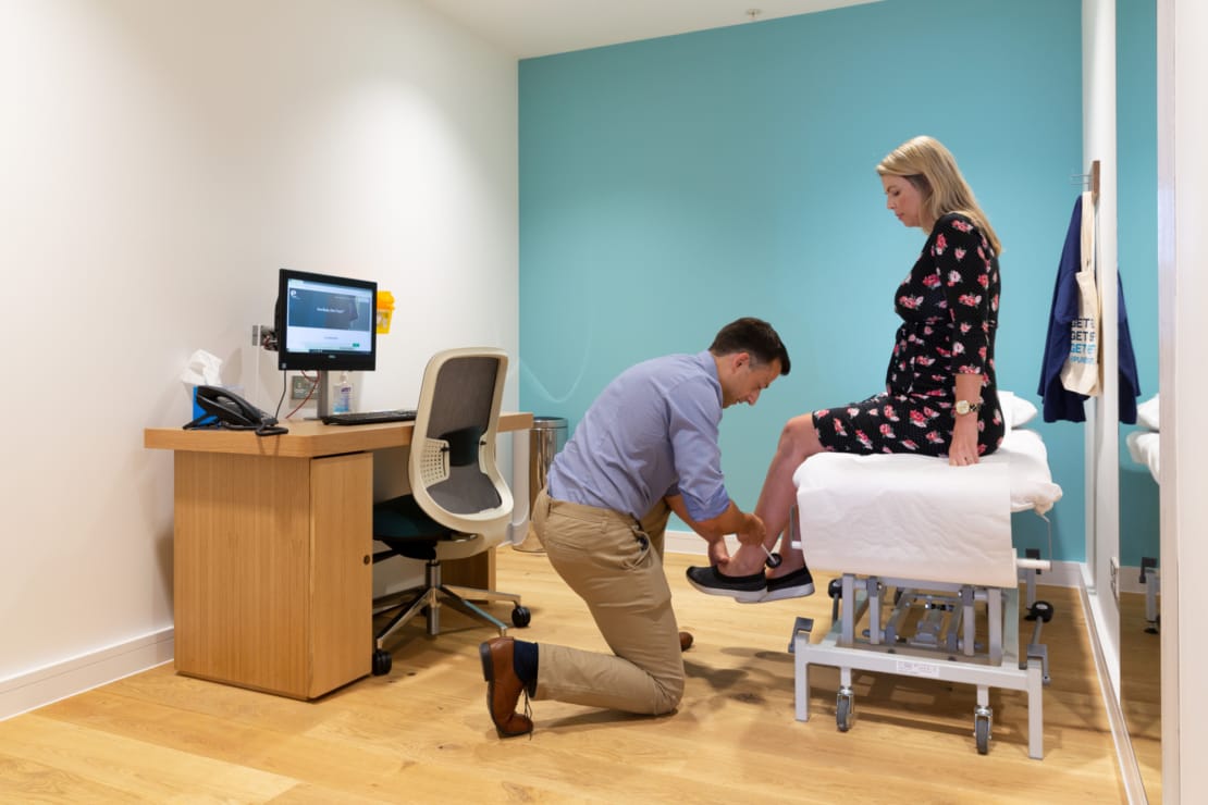 clinician assessing patient's feet in appointment room